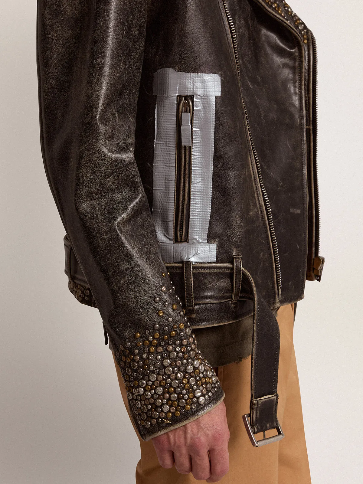 Men's leather biker jacket with hammered studs and adhesive tape